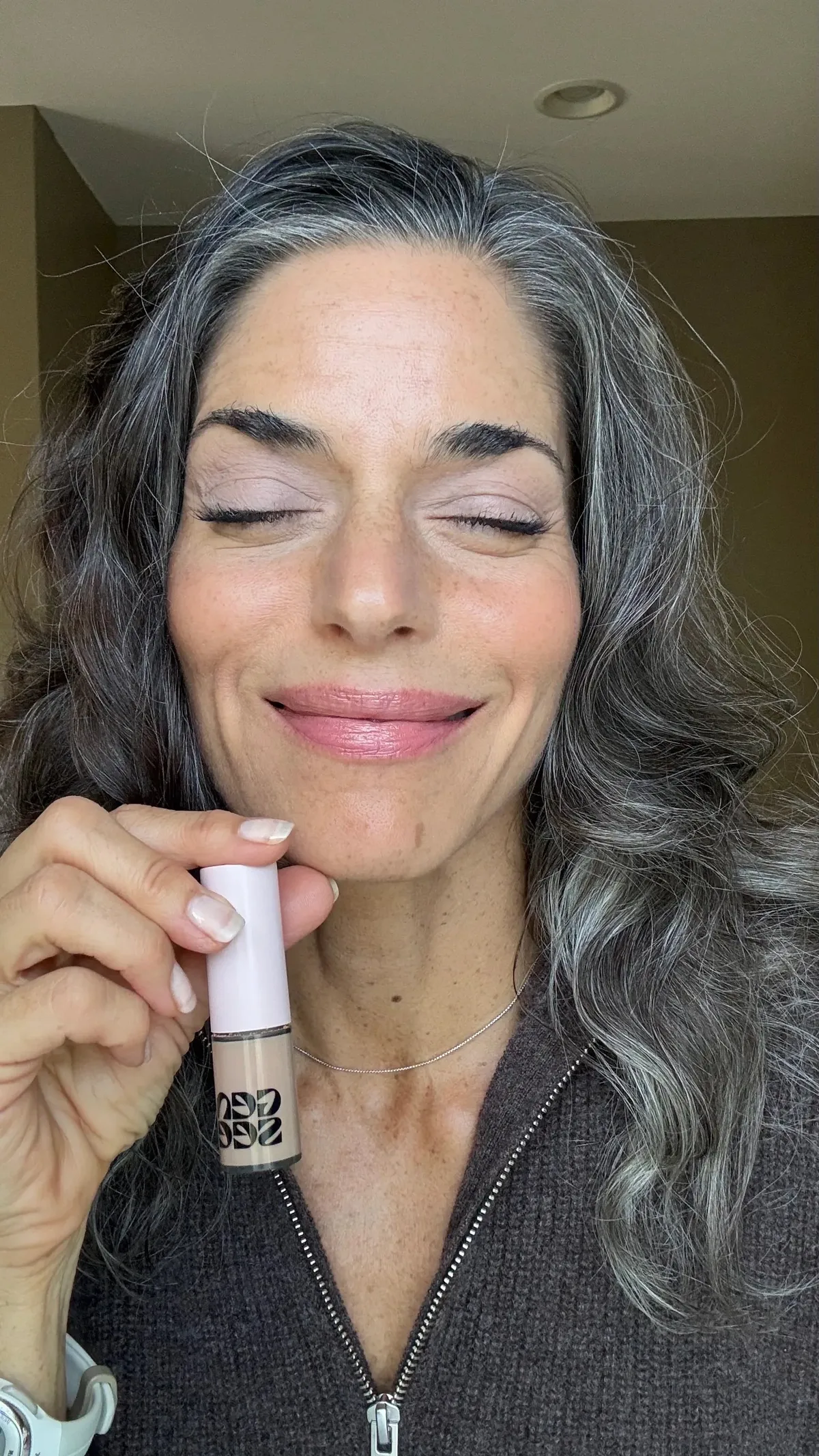 Model holding Gen See liquid eyeshadow with eyes open
