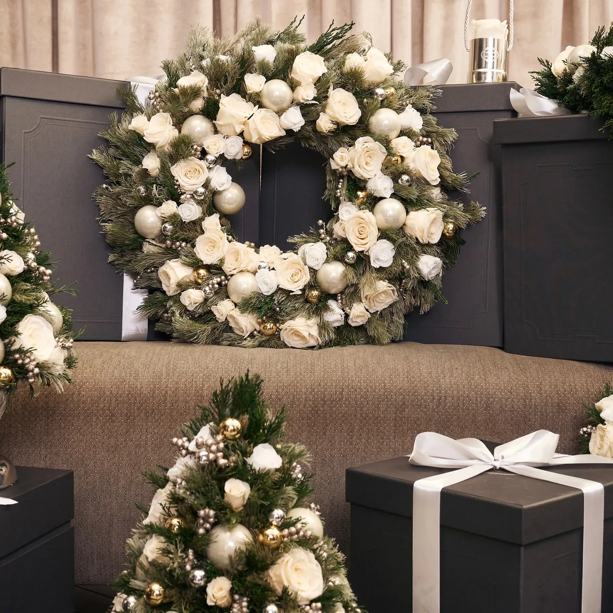 Déco d’Or Tabletop Trees styled with a floral wreath, metallic ornaments and ribboned holiday gifts