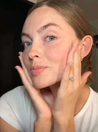 Lani pressing Facial Treatment Essence into her cheeks