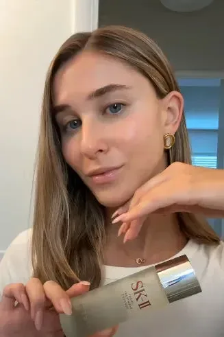 Becca holding SK-II PITERA Essence