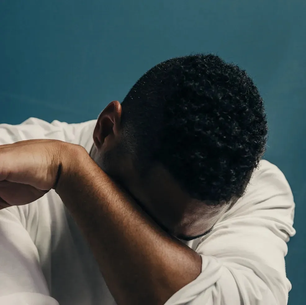 Person taking a quiet moment with their head resting on their arms