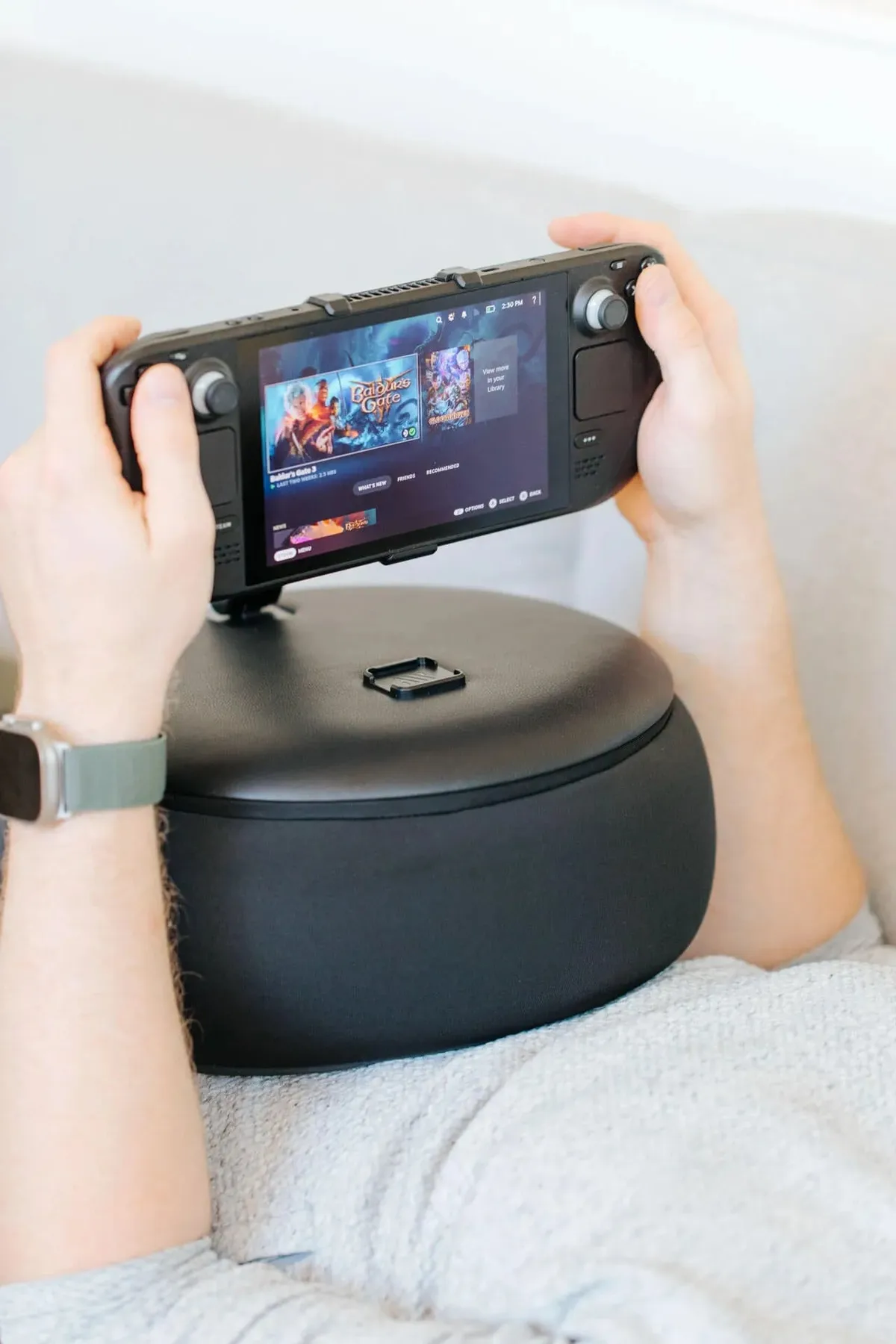 Close-up of a handheld supported by the Gaming Pillow on a gamer’s lap